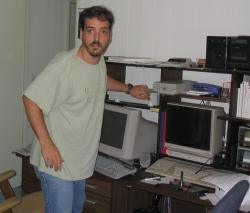 Picture of me in my “lair.”  Actually have my beard and moustache.  2003-06-29, taken by my dad.  (Not all hardware visible.)